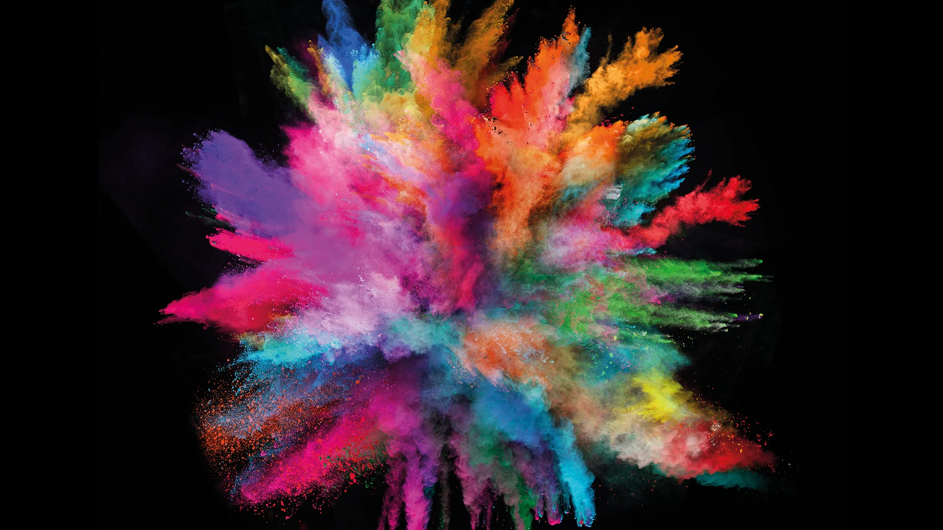 Colorful powder paints explode in front of dark background