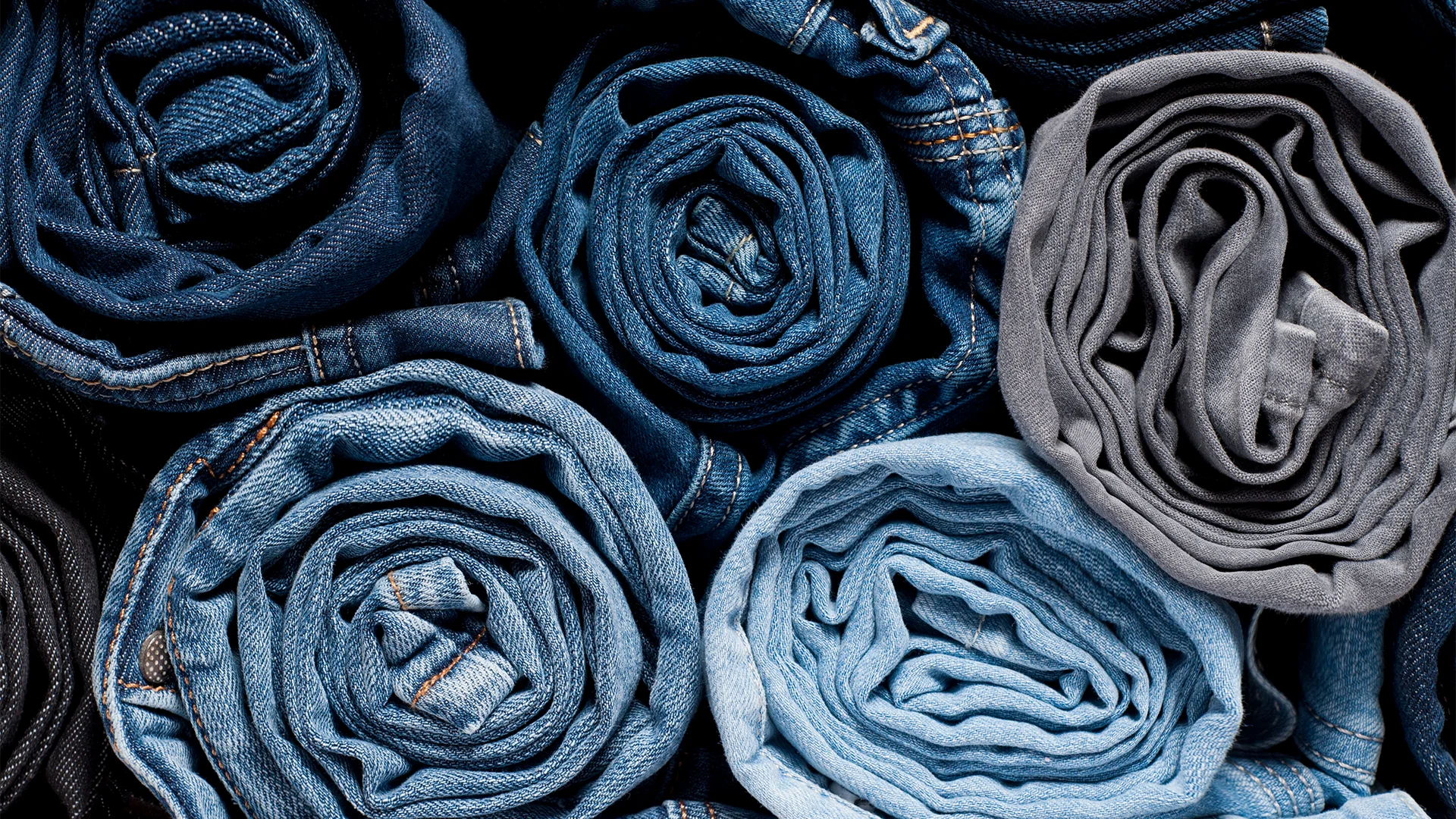Different colored jeans rolled up on top of each other (Photo)